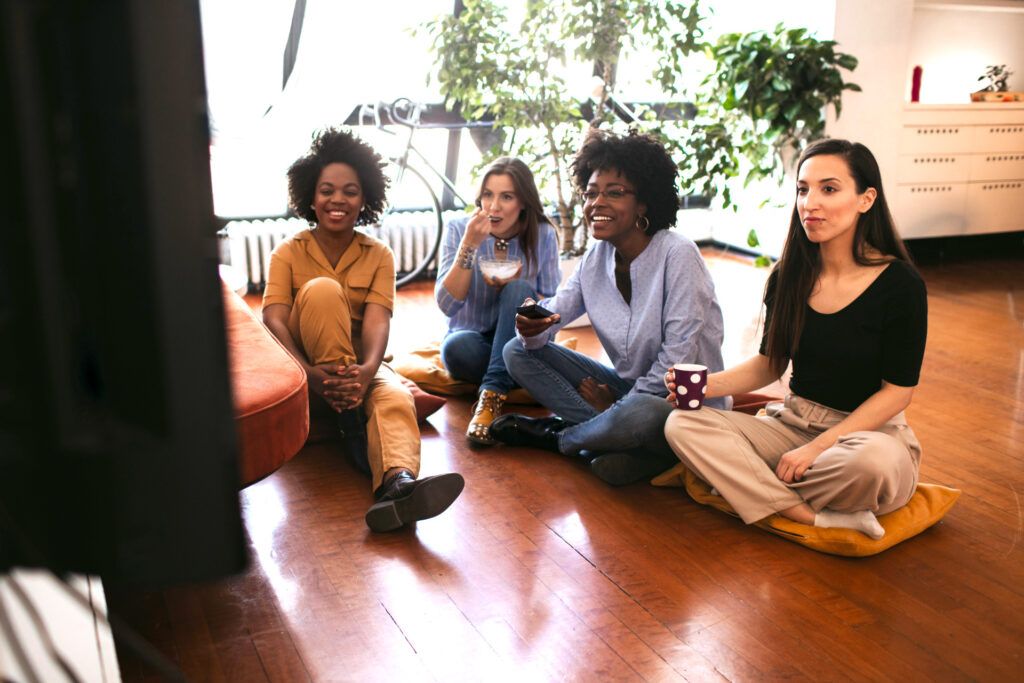 Four women watching something on television